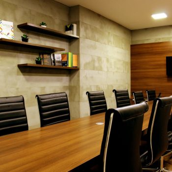 Chairs pushed up against the side of a long desk in a meeting area