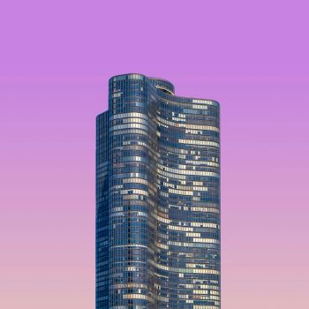 A skyscraper against a purple sky background