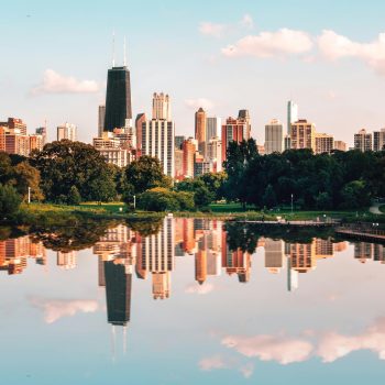 The Chicago skyline reflected against the surface of a nearby body of water