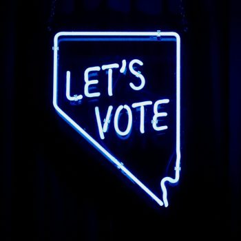 A blue neon sign reading "Let's vote"