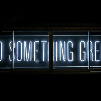 A blue neon sign reading "Do something great"